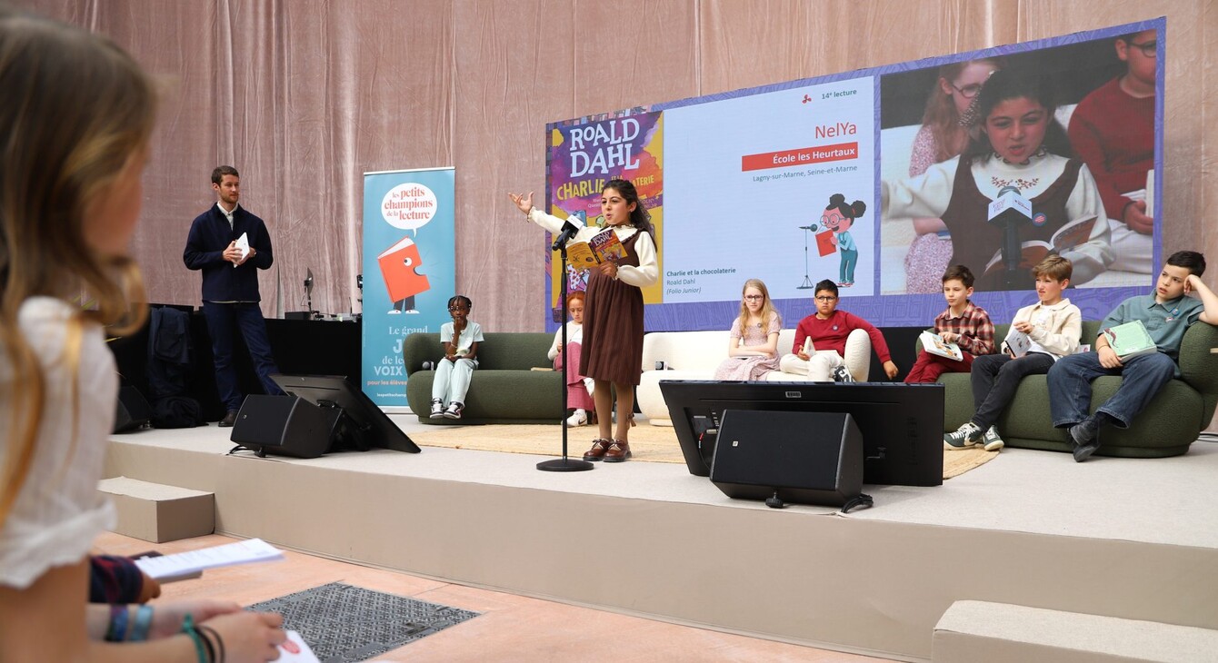 Nelya en pleine lecture lors de la finale IDF des Petits Champions de la Lecture 2026 au Grand Palais